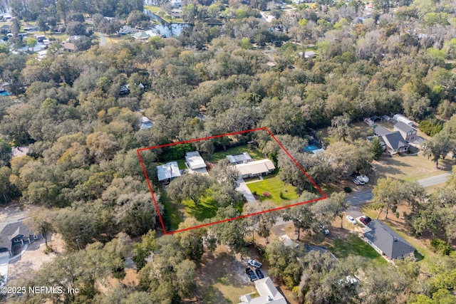 birds eye view of property featuring a forest view