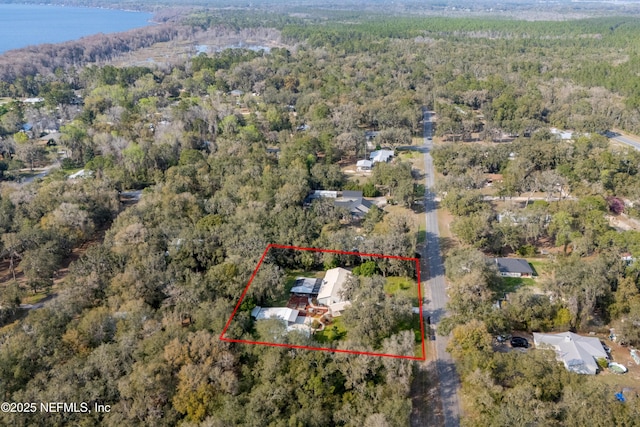 birds eye view of property with a water view and a view of trees