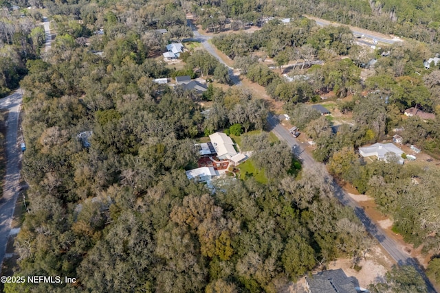 birds eye view of property featuring a forest view