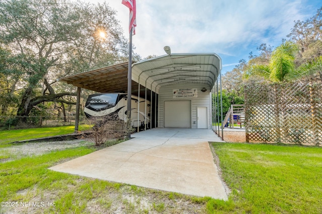 view of parking / parking lot with concrete driveway and a detached garage