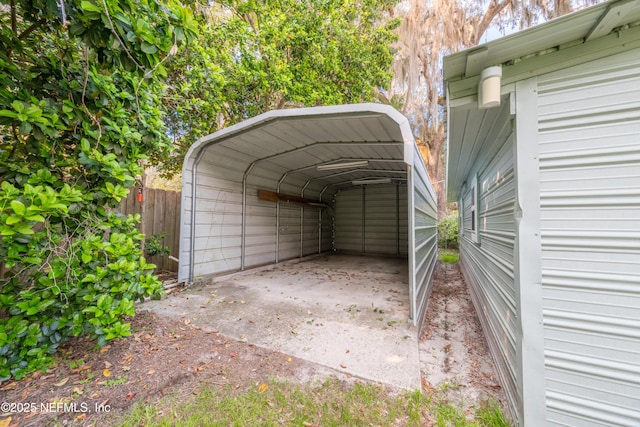 view of car parking with fence and a carport