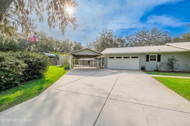 ranch-style home with metal roof, an attached garage, driveway, stucco siding, and a front yard