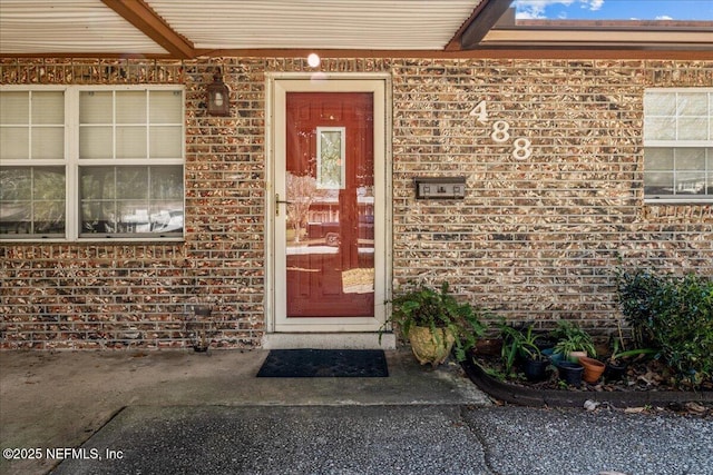 view of exterior entry with brick siding