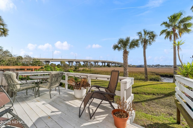 deck with outdoor dining space and a yard