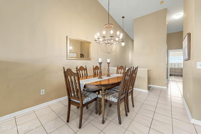 dining room with light tile patterned floors, a high ceiling, baseboards, and a notable chandelier