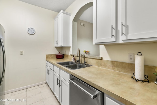 kitchen featuring stainless steel appliances, a sink, white cabinetry, baseboards, and light countertops