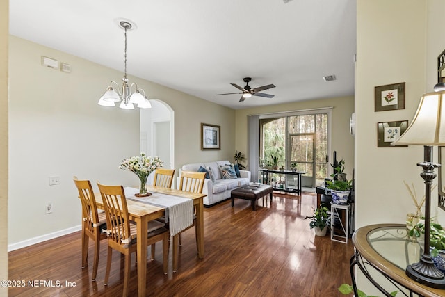 dining room featuring arched walkways, visible vents, dark wood finished floors, and baseboards