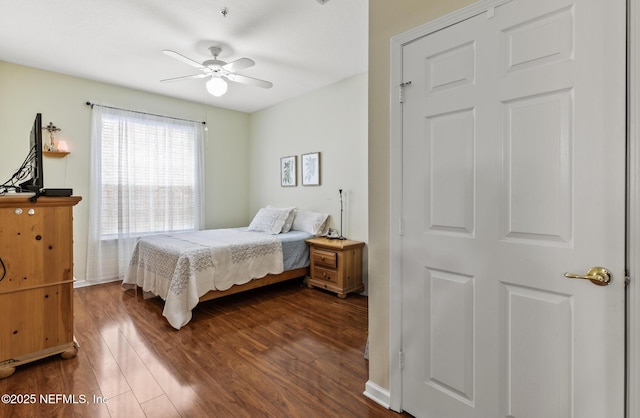 bedroom featuring dark wood-type flooring, baseboards, and a ceiling fan