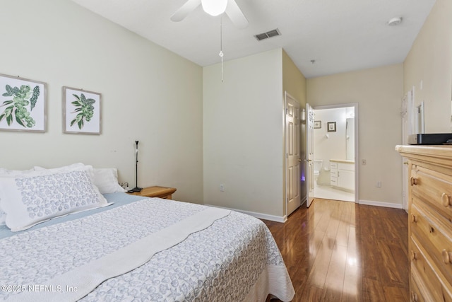 bedroom featuring ensuite bathroom, dark wood-type flooring, a ceiling fan, visible vents, and baseboards