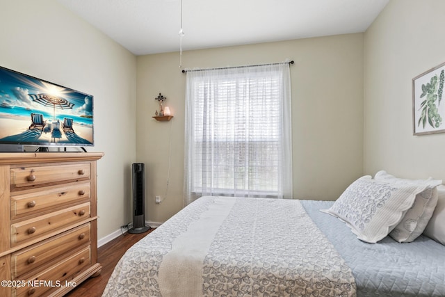 bedroom with dark wood-type flooring and baseboards