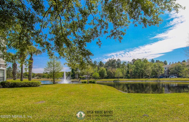 view of community featuring a water view and a lawn