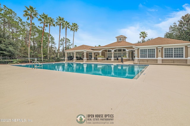 community pool with fence and a patio