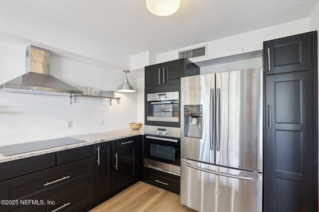 kitchen with open shelves, stainless steel appliances, visible vents, dark cabinets, and wall chimney exhaust hood