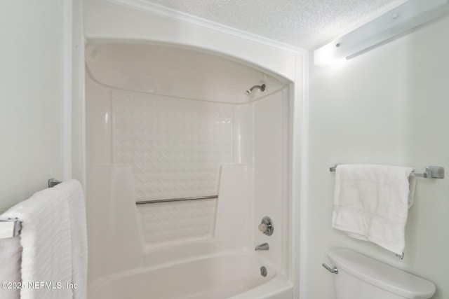 bathroom with toilet, tub / shower combination, and a textured ceiling