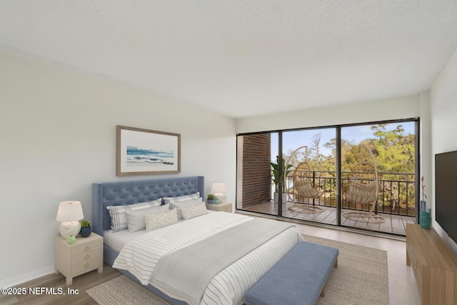 bedroom featuring access to outside, wood finished floors, and baseboards