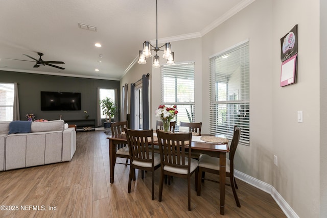 dining area with visible vents, baseboards, ceiling fan, wood finished floors, and crown molding