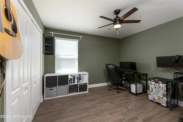 office featuring ceiling fan, a textured ceiling, baseboards, and wood finished floors