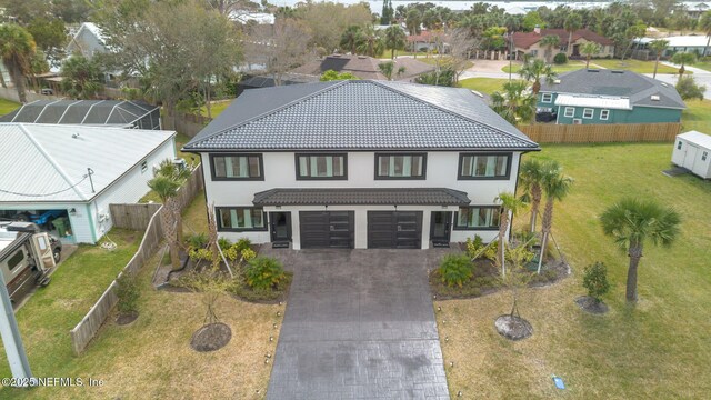 view of front of home with a garage, a tiled roof, decorative driveway, and fence