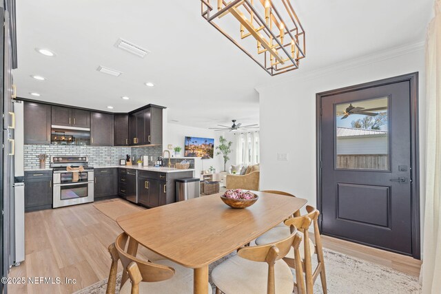 dining space with crown molding, recessed lighting, visible vents, light wood-style floors, and ceiling fan