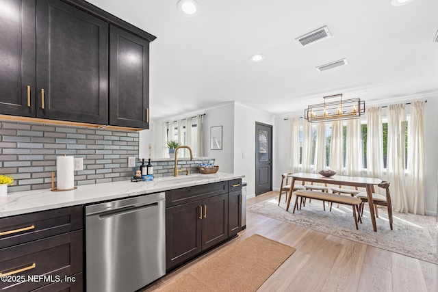 kitchen featuring light wood-style flooring, a sink, visible vents, ornamental molding, and dishwasher