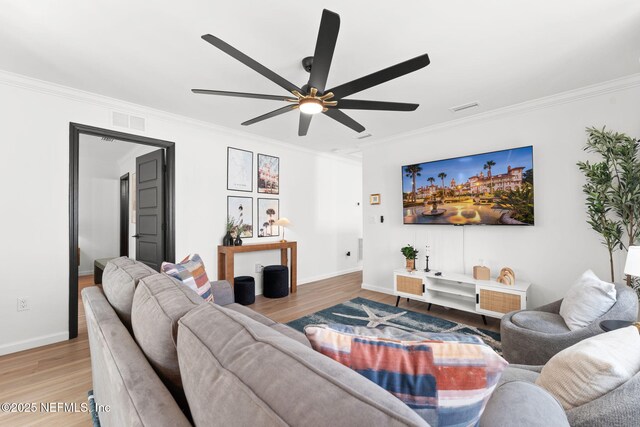 living room featuring crown molding, visible vents, and light wood-style floors