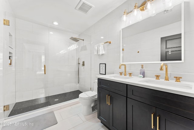 bathroom featuring visible vents, a sink, tile walls, and toilet