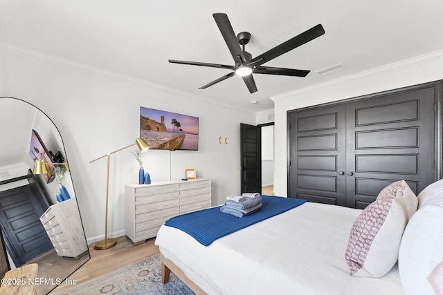 bedroom with ceiling fan, wood finished floors, visible vents, baseboards, and ornamental molding