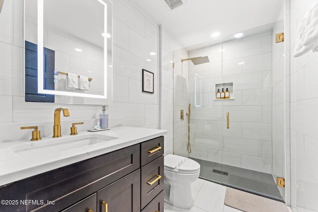 full bath with a shower stall, visible vents, tile walls, and toilet