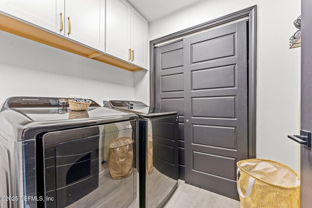 laundry room featuring washing machine and dryer and cabinet space