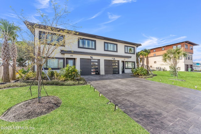 view of front of home featuring a garage, a front yard, driveway, and stucco siding