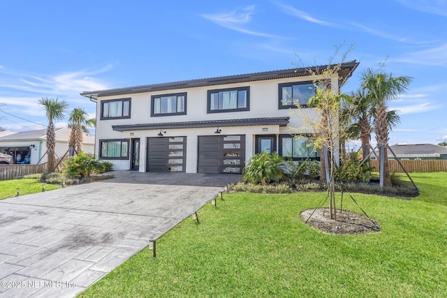 view of front facade featuring driveway, a garage, stucco siding, fence, and a front yard