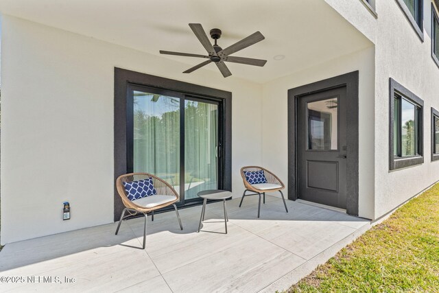 property entrance with a ceiling fan and stucco siding