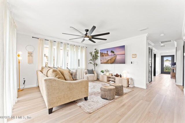 living area with light wood-style floors, crown molding, and baseboards