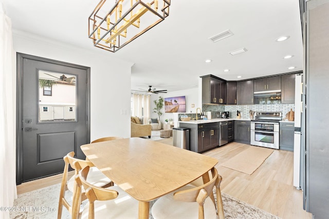 kitchen featuring visible vents, decorative backsplash, dark brown cabinets, light wood-type flooring, and double oven range