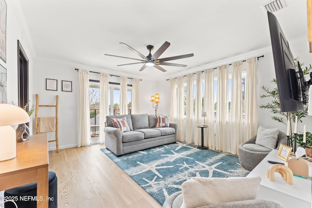 living room featuring ornamental molding, visible vents, light wood-style floors, and ceiling fan