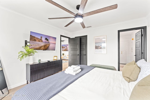 bedroom featuring ceiling fan, wood finished floors, visible vents, baseboards, and crown molding