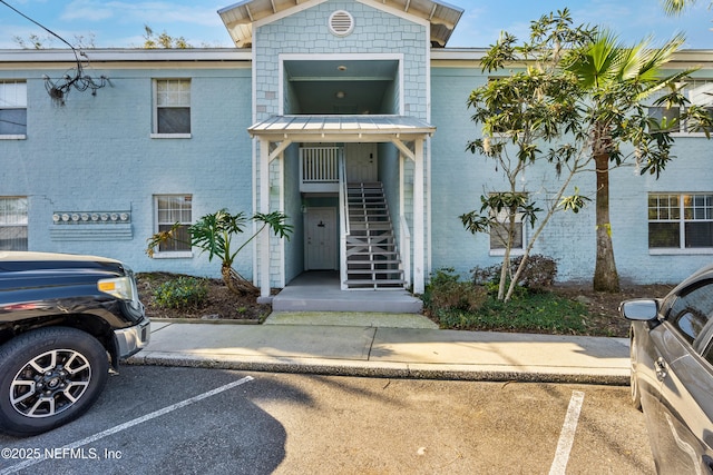 exterior space with uncovered parking and brick siding