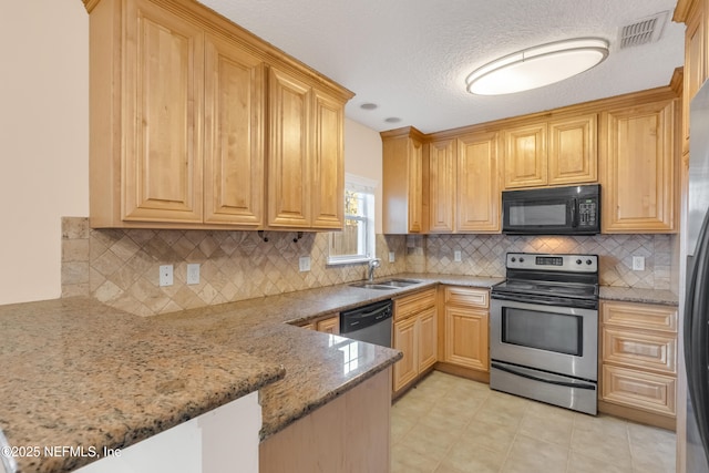 kitchen featuring a peninsula, a sink, visible vents, appliances with stainless steel finishes, and light stone countertops