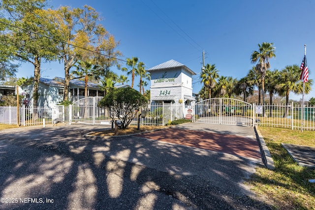 view of front of house with a gate, driveway, and fence