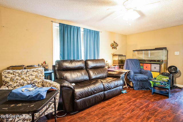 living area with ceiling fan, a textured ceiling, and wood finished floors