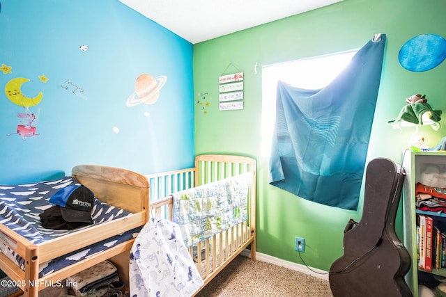 carpeted bedroom with a nursery area and baseboards