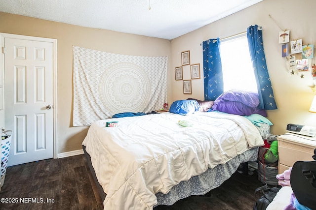 bedroom with baseboards and wood finished floors