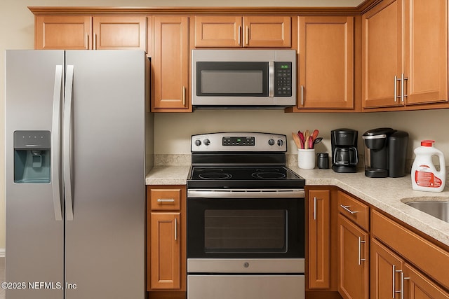 2277 Stauffer Rd, Green Cove Springs, FL 32043 - kitchen with appliances with stainless steel finishes, light countertops, and brown cabinetry