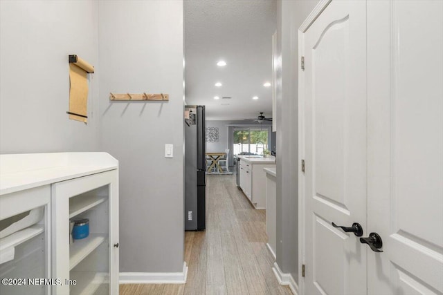 interior space with baseboards, recessed lighting, and light wood-style floors