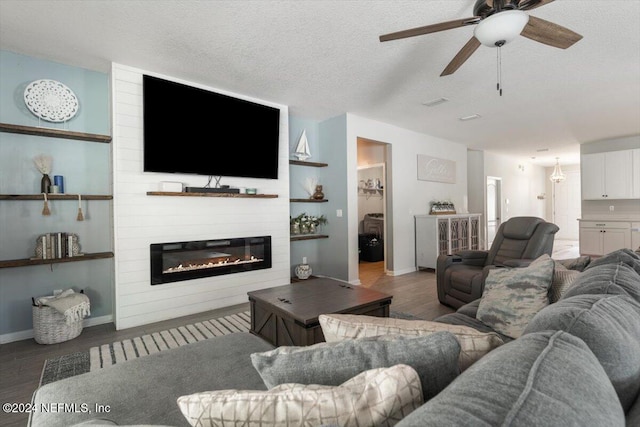 living room featuring a fireplace, a ceiling fan, a textured ceiling, wood finished floors, and baseboards