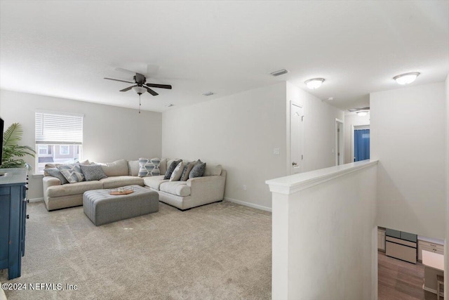 carpeted living room featuring visible vents, ceiling fan, and baseboards