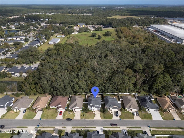 drone / aerial view featuring a residential view and a view of trees