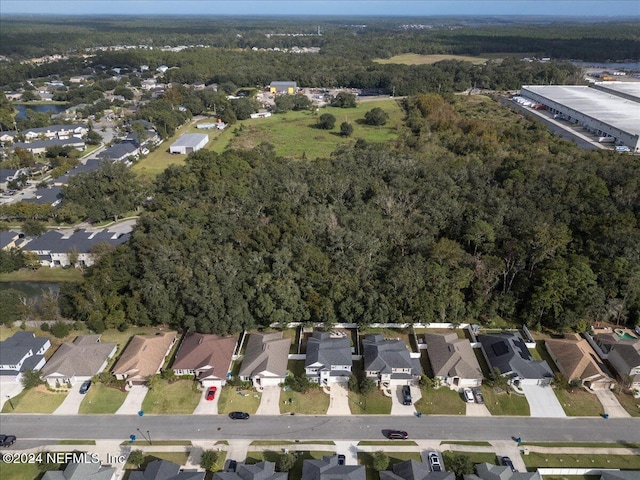 drone / aerial view with a residential view and a view of trees