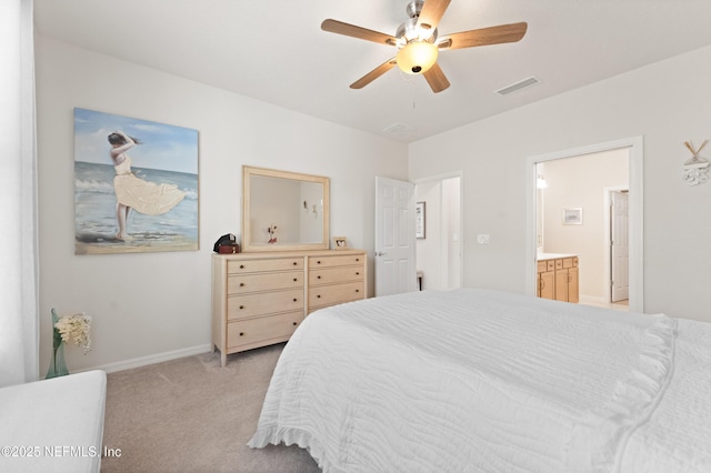 bedroom featuring ceiling fan, ensuite bathroom, light colored carpet, visible vents, and baseboards