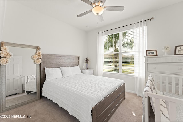 bedroom featuring a ceiling fan, light carpet, and baseboards